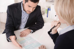 Hombre y mujer con documentos sentados en actitud de revisión de documentación